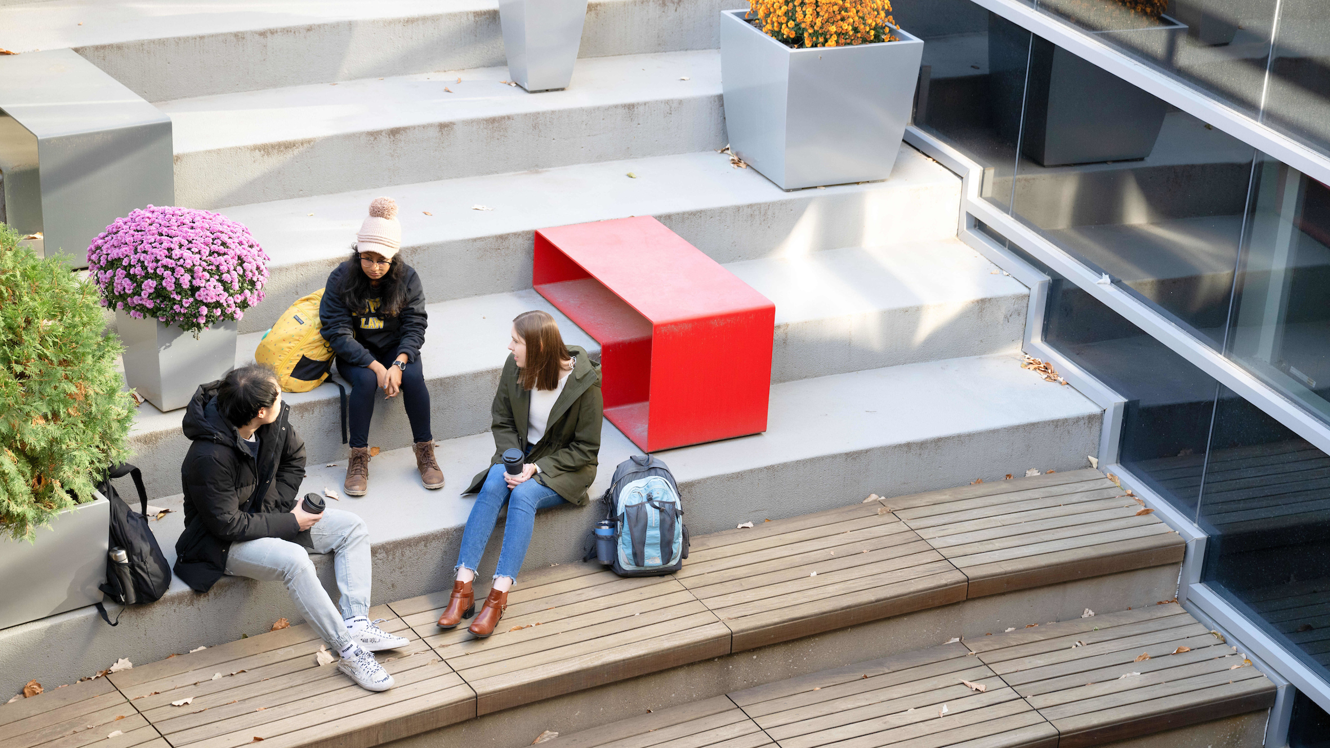 Aerial view of students sit in the Seldin Portico during fall.