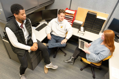 Luke Kennedy (center) talks with others on the JCL editorial board.